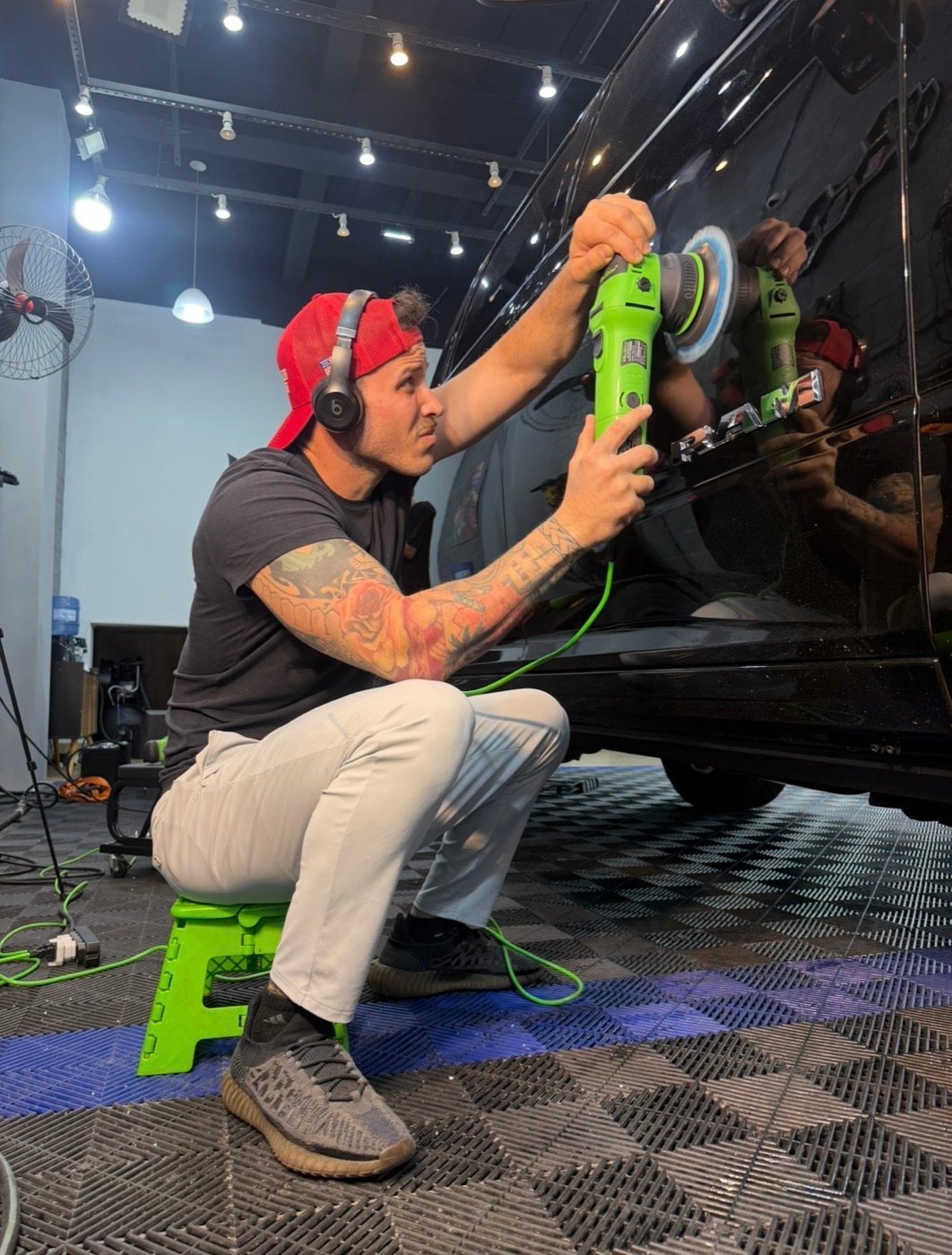 Minty detailer machine-polishing a black RAM pickup